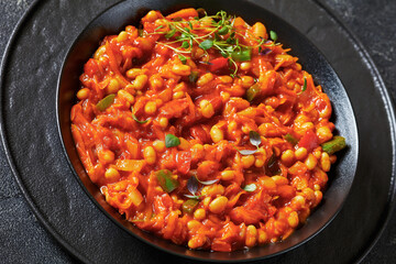 chakalaka, spicy tomato bean relish in black bowl