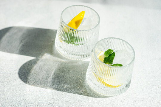 Refreshing gin tonic drinks with lemon garnish