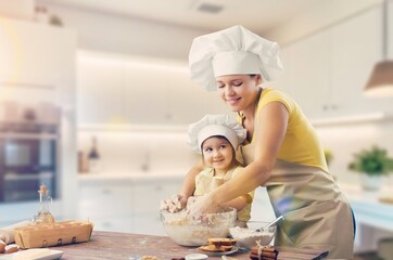 Happy mother with young daughter do homemade dough