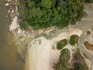 A small river joining the sea on the beach. Small bridge, Penang, Malaysia.