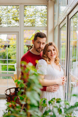 Naklejka premium Man and woman at the window of a country house