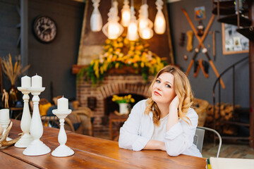 Portrait of attractive blonde woman at table in cozy house in retro style.