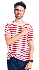 Obraz premium Young hispanic man wearing casual clothes cheerful with a smile on face pointing with hand and finger up to the side with happy and natural expression