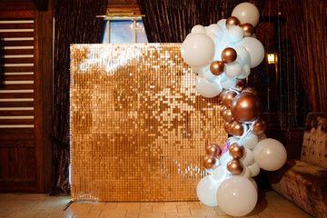 Photo zone with gold sequins and white and gold balloons. 