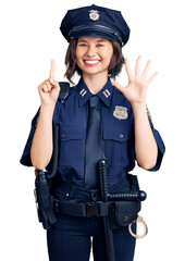 Young beautiful girl wearing police uniform showing and pointing up with fingers number six while smiling confident and happy.