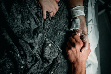 A loved one in hospital. Holding the patient's hand.