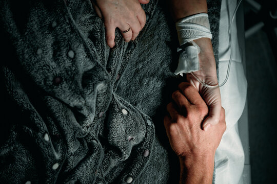 A loved one in hospital. Holding the patient's hand.