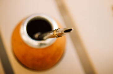 Mate calabash with bombilla on a light warm background. Healthy infused drink, classic Yerba mate...