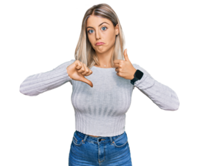 Beautiful blonde woman wearing casual clothes doing thumbs up and down, disagreement and agreement expression. crazy conflict