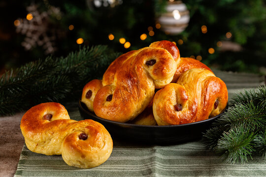 Homemade  swedish St Lucia saffron buns.  Also called  lussekatt or lussebulle, Cornish tea treat bun or revel bun, is a spiced yeast-leavened sweet bun with  raisins. Christmas tree.