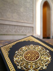 ook cover of holy Quran with bokeh background of mosque wall. Quran with bokeh background. Quran recitation in Ramadan.

