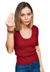 Fototapeta premium Young blonde girl wearing casual clothes doing italian gesture with hand and fingers confident expression