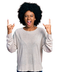 Young african american woman wearing casual clothes shouting with crazy expression doing rock symbol with hands up. music star. heavy concept.