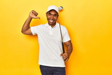 African American man golfer, yellow studio backdrop, feels proud and self confident, example to...