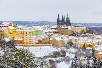 Snowy Prague City with gothic Castle from the Hill Petrin, Czech republic