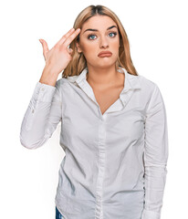 Young caucasian woman wearing casual clothes shooting and killing oneself pointing hand and fingers to head like gun, suicide gesture.