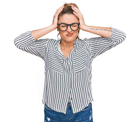 Young caucasian woman wearing business shirt and glasses suffering from headache desperate and stressed because pain and migraine. hands on head.