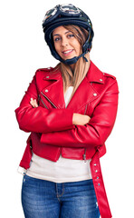 Young beautiful woman wearing motorcycle helmet happy face smiling with crossed arms looking at the camera. positive person.