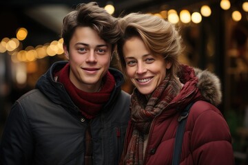 A couple embraces the chilly winter weather, their beaming smiles framed by stylish jackets and scarves as they pose for a photo on a bustling street