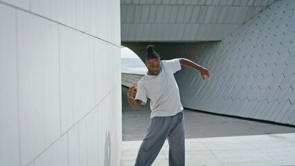 Inspired dancer practicing choreography at street. Active man dancing freestyle