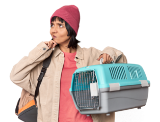 Young Hispanic woman ready for travel with pet carrier dreaming of achieving goals and purposes