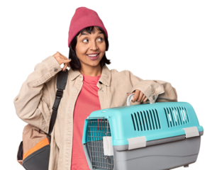 Young Hispanic woman ready for travel with pet carrier pointing upside with opened mouth.