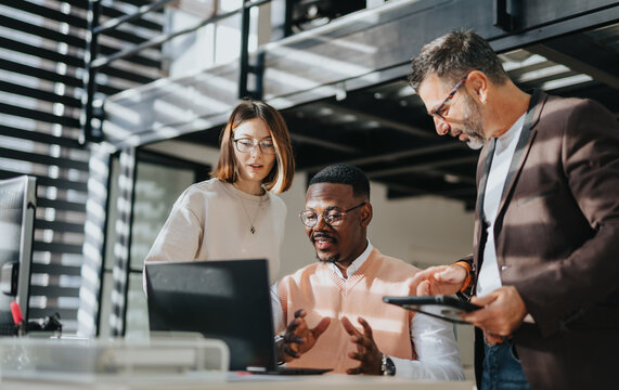 A diverse group collaborates on business growth, discussing market analysis and global expansion. They work together in a corporate office, strategizing for success and sustainability. - Powered by Adobe