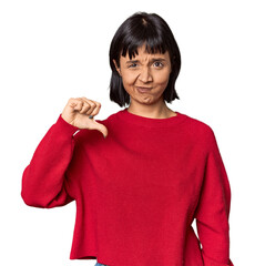 Young Hispanic woman with short black hair in studio showing a dislike gesture, thumbs down. Disagreement concept.