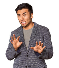 Young Chinese man in studio background rejecting someone showing a gesture of disgust.
