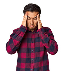 Young Chinese man in studio background touching temples and having headache.