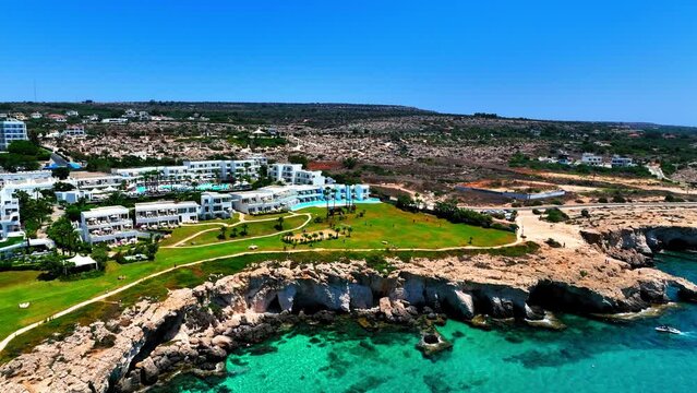 Aerial Beautiful View Of Hotel Buildings On Cliff By Sea, Drone Flying Forward During Sunny Day - Famagusta, Cyprus