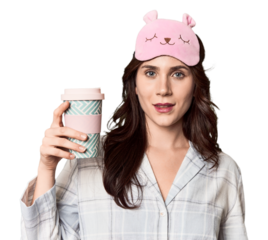 Young Caucasian in pajamas with to-go coffee in studio