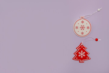 minimal lilac background with Red and white wooden toys: Christmas tree and ball. Zero waste, handmade, diy concept.