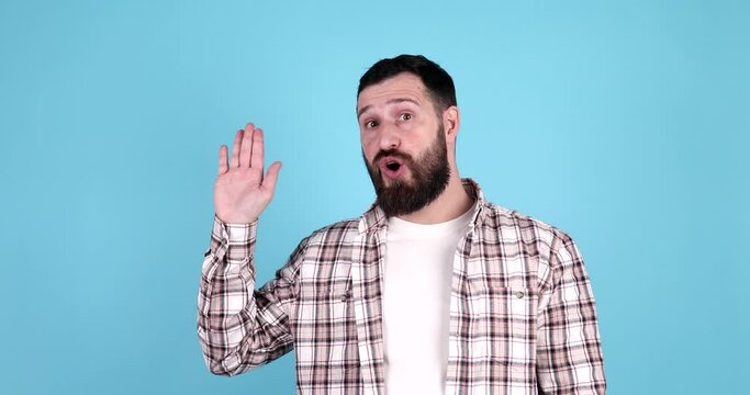 Young handsome bearded man wearing casual waiving saying hello happy and smiling, friendly welcome gesture on blue background.
