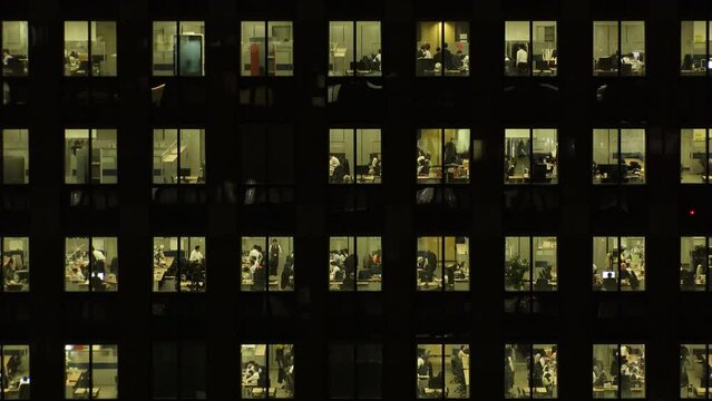 TOKYO, JAPAN : Close up shot of exterior of office building window at night. Company, corporate, job, work and business people concept video. Time lapse shot. 