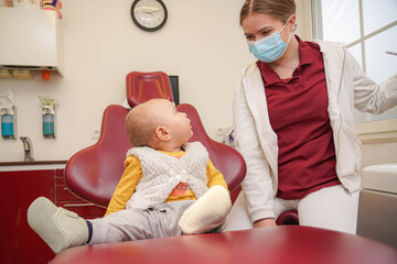 A small child looks carefully at a dentist for examination and treatment of small teeth. Newborn child at the dentist.
