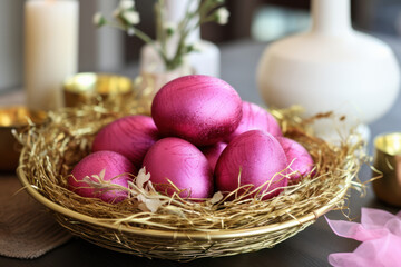 Fototapeta na wymiar Vibrant pink Easter eggs nestled in a gold nest with delicate flowers, against a backdrop of white candles.