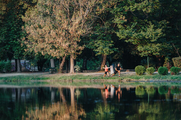 Two fit, caucasian friends warm up outdoors in park.