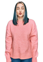 Young modern girl wearing pink wool winter sweater making fish face with lips, crazy and comical gesture. funny expression.