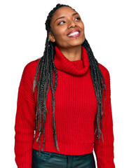 African american woman wearing casual winter sweater looking away to side with smile on face, natural expression. laughing confident.