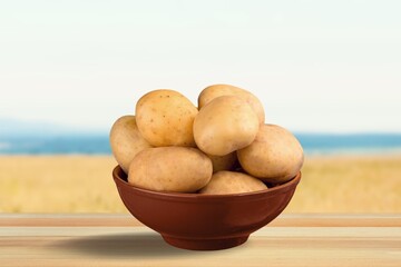 Fresh potatoes on table at green field on sunset