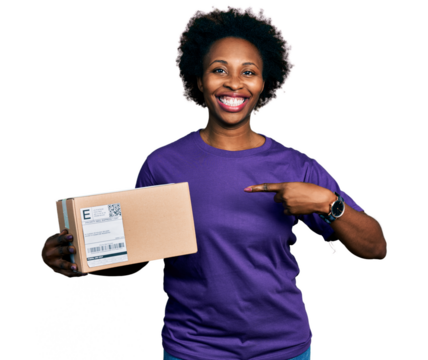 African american woman with afro hair holding delivery package smiling happy pointing with hand and finger