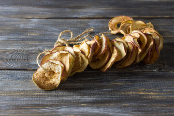 Homemade dried apples with cinnamon, apple chips on a wooden background. Delicious healthy snack
