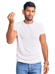 Young latin man wearing casual clothes doing italian gesture with hand and fingers confident expression