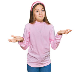 Beautiful brunette little girl wearing casual turtleneck sweater clueless and confused expression...