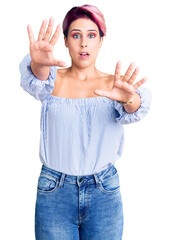 Young beautiful woman with pink hair wearing casual clothes doing stop gesture with hands palms, angry and frustration expression