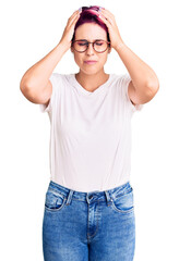 Young beautiful woman with pink hair wearing casual clothes and glasses suffering from headache desperate and stressed because pain and migraine. hands on head.