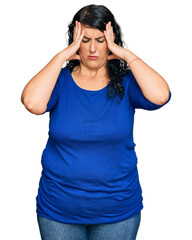 Obraz na płótnie Canvas Plus size brunette woman wearing casual clothes suffering from headache desperate and stressed because pain and migraine. hands on head.