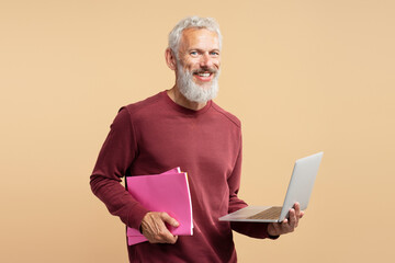 Handsome smiling gray haired business man, bearded hipster holding laptop computer looking at...