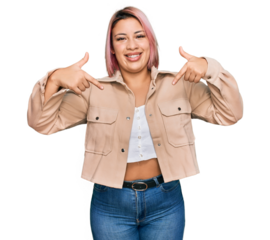 Hispanic woman with pink hair wearing casual clothes looking confident with smile on face, pointing oneself with fingers proud and happy.